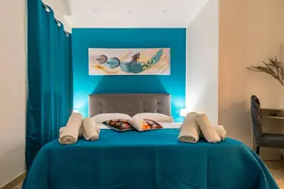 a bedroom with a blue bed with pillows at Il Palchetto in Palermo