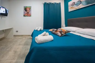 a bedroom with a blue bed with towels on it at Il Palchetto in Palermo