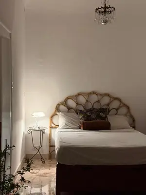 a bedroom with a large bed with a chandelier at Locanda Lupo in Palermo