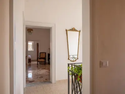 a hallway with a mirror on the wall and a chair at Locanda Lupo in Palermo