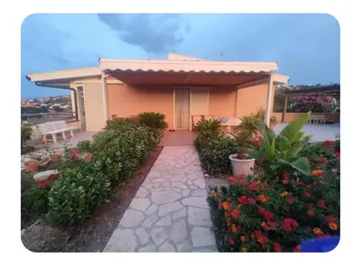 a house with a pathway leading to it with flowers at Cas'aMare Holidays, Home is Love in Castellammare del Golfo