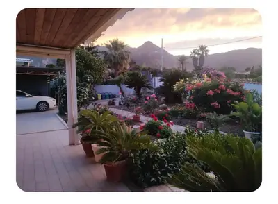 a garden with potted plants and flowers on a patio at Cas'aMare Holidays, Home is Love in Castellammare del Golfo