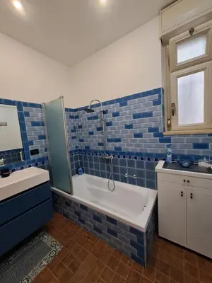 a blue tiled bathroom with a tub and a sink at Emily's Place in Palermo