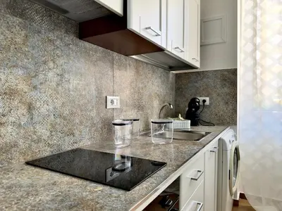 a kitchen with white cabinets and a counter top at MD Apartament Coral Bahalara 2 in Palermo