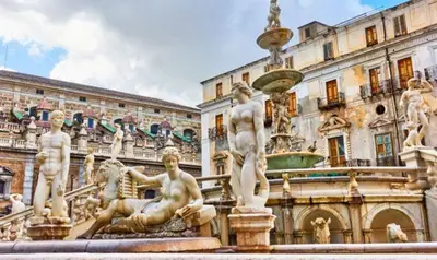 a fountain with statues in front of a building at MD Apartament Coral Bahalara 2 in Palermo