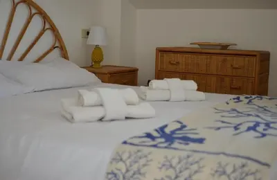 a bedroom with two beds with white pillows and a bed sidx sidx at Maioliche Rooms in Campofelice di Roccella