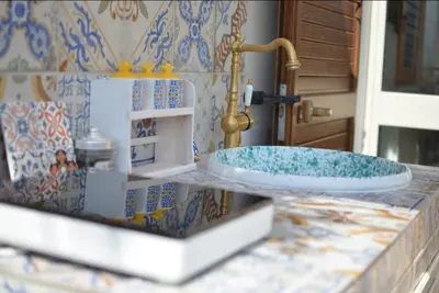 a bathroom counter with a sink and a faucet at Maioliche Rooms in Campofelice di Roccella