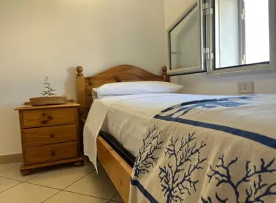 a bedroom with a bed and a dresser and a window at Maioliche Rooms in Campofelice di Roccella
