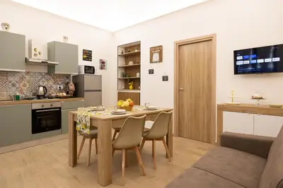 a kitchen and dining room with a wooden table and chairs at Lemora in Palermo