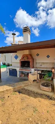 a house with a brick fireplace in the backyard at Villa Calatafimi Segesta in Calatafimi