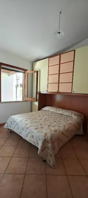 a bedroom with a large bed with a wooden headboard at Villa Calatafimi Segesta in Calatafimi