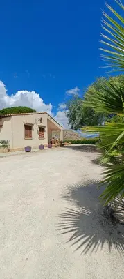 a building with a palm tree in front of it at Villa Calatafimi Segesta in Calatafimi