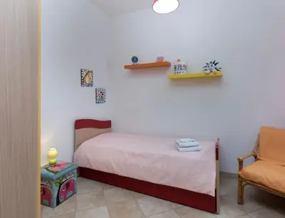 a bedroom with a bed and a chair at Indipendente a S vito lo Capo in San Vito lo Capo