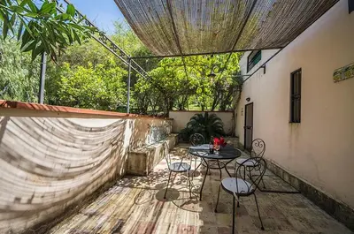a patio with a table and chairs and a fence at Casa Laghetto in the countryside with a shared pool in Terrasini