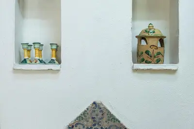 a wall with three vases and a bird house at Casa Laghetto in the countryside with a shared pool in Terrasini