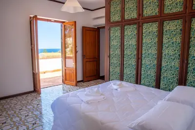 a bedroom with a bed with a view of the ocean at LuminHouse Addaura Pool in Palermo