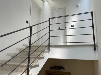 a staircase with glass railings in a house at Casetta Ciurì in Terrasini