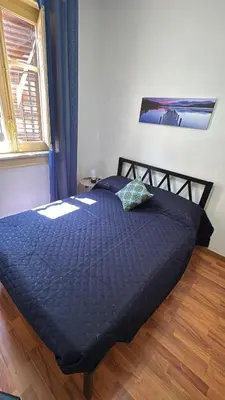 a bed with a blue comforter in a bedroom at Petit Charme in Palermo