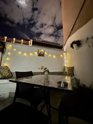 a table and chairs in a room with a sky at Petit Charme in Palermo