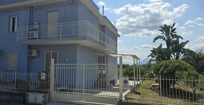 a blue building with a balcony and a fence at SOLUNTUM - locazione turistica in Santa Flavia