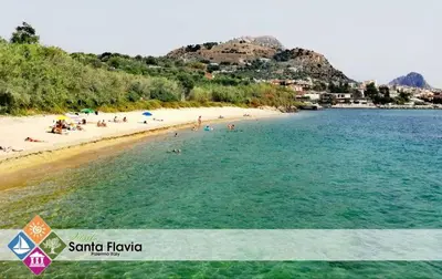 a beach with a group of people in the water at SOLUNTUM - locazione turistica in Santa Flavia