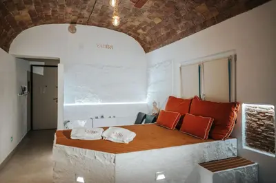 a bedroom with a large bed with orange pillows at Zahira suite&spa in Palermo