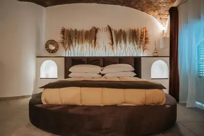 a bedroom with a large bed with a wooden headboard at Zahira suite&spa in Palermo