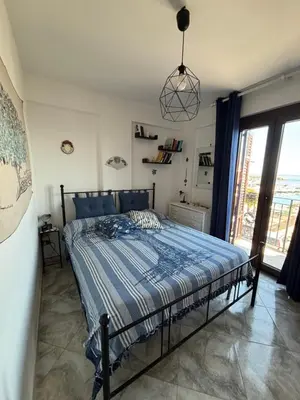 a bedroom with a bed with a blue comforter at Sumarè in Isola delle Femmine