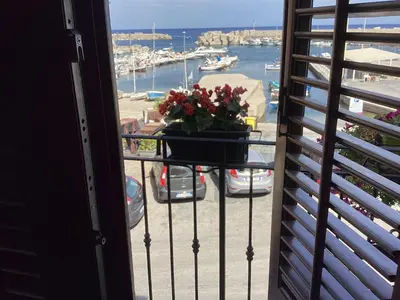 a balcony with a pot of flowers on a table at Sumarè in Isola delle Femmine