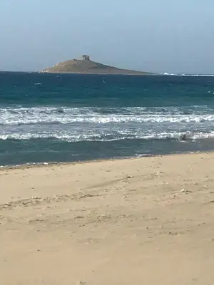 a beach with an island in the ocean at Sumarè in Isola delle Femmine