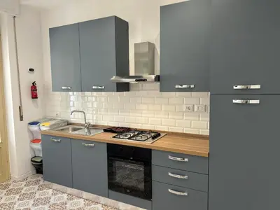 a kitchen with a sink and a stove top oven at Balhara Floridi House in Palermo