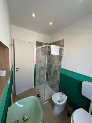 a bathroom with a shower and a toilet and a sink at Balhara Floridi House in Palermo