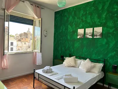 a bedroom with a bed with a green wall at Balhara Floridi House in Palermo