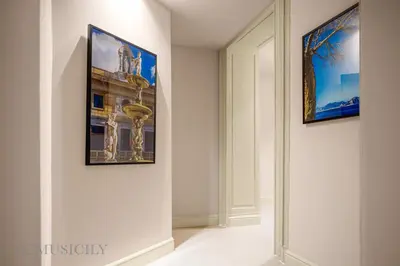 a hallway with two pictures on the walls of a museum at Palazzo Cavarretta - Le Stanze dei Baroni in Palermo