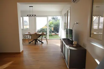 a living room with a kitchen and a dining table at Magnolia Home in Terrasini