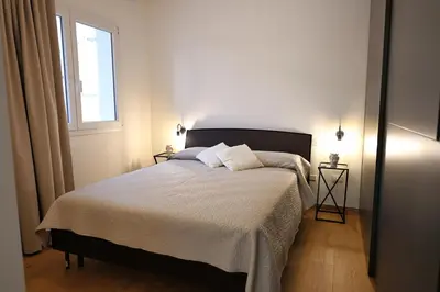 a bedroom with a bed with two pillows and a window at Magnolia Home in Terrasini