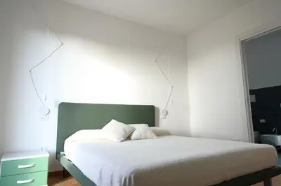 a bedroom with a bed with a green headboard at Magnolia Home in Terrasini