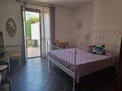 a bedroom with a bed with a purple comforter at Villa indipendente con piscina in Terrasini