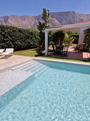 a swimming pool in front of a house at Villa indipendente con piscina in Terrasini