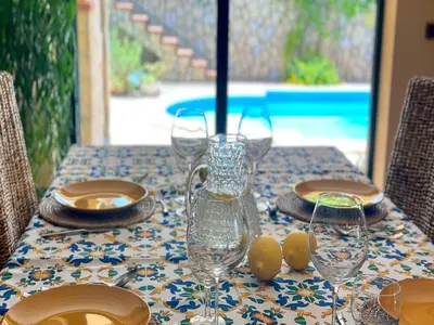 a table with glasses and plates on a table with a table cloth at Villa in Palermo near the Sea in Altofonte