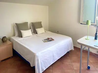 a bedroom with a white bed with a book on it at Villa in Palermo near the Sea in Altofonte