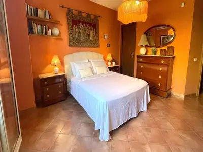 a bedroom with a white bed and two night stands at Villa in Palermo near the Sea in Altofonte