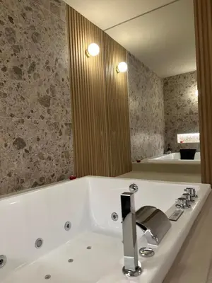 a bathroom with a large white bath tub with a mirror at House Spa Palermo in Palermo
