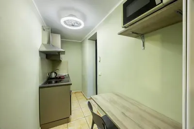 a small kitchen with a wooden table and a sink at Ramona House in Palermo