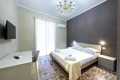 a bedroom with a large bed and a chandelier at Anita House in Palermo