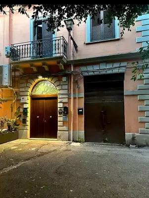 a building with a brown door and a balcony at Sant'Oliva House Palermo in Palermo