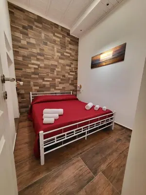 a bedroom with a red bed with towels on it at marino casa vacanze in Carini