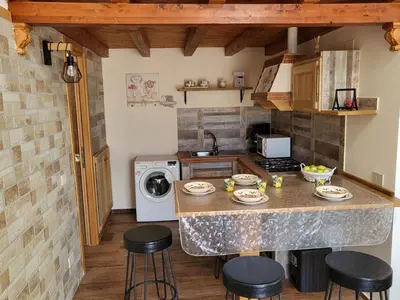 a kitchen with a counter with stools and a sink at marino casa vacanze in Carini