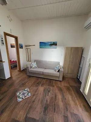 a living room with a couch and wooden floors at marino casa vacanze in Carini