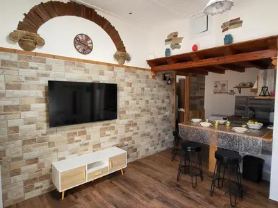a kitchen with a brick wall with a tv on it at marino casa vacanze in Carini
